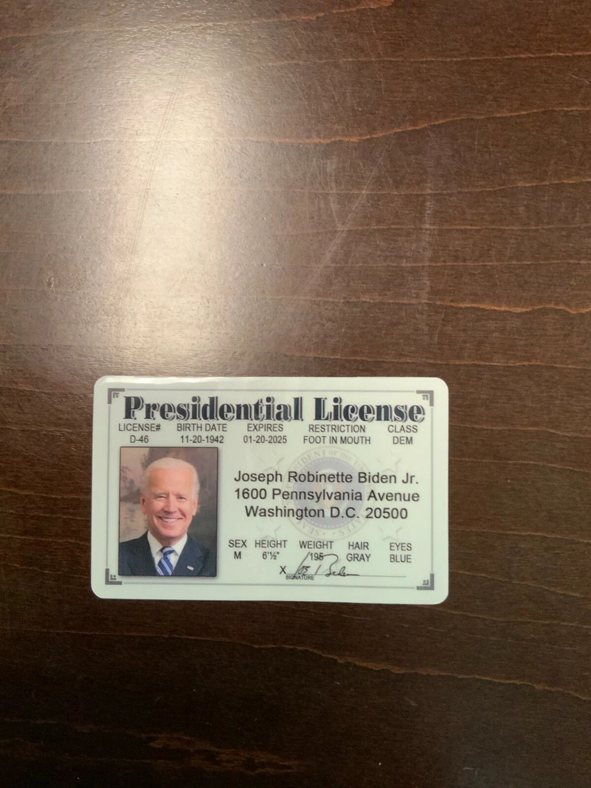 Biden & Harris ID cards with black background, white text, and green seals.